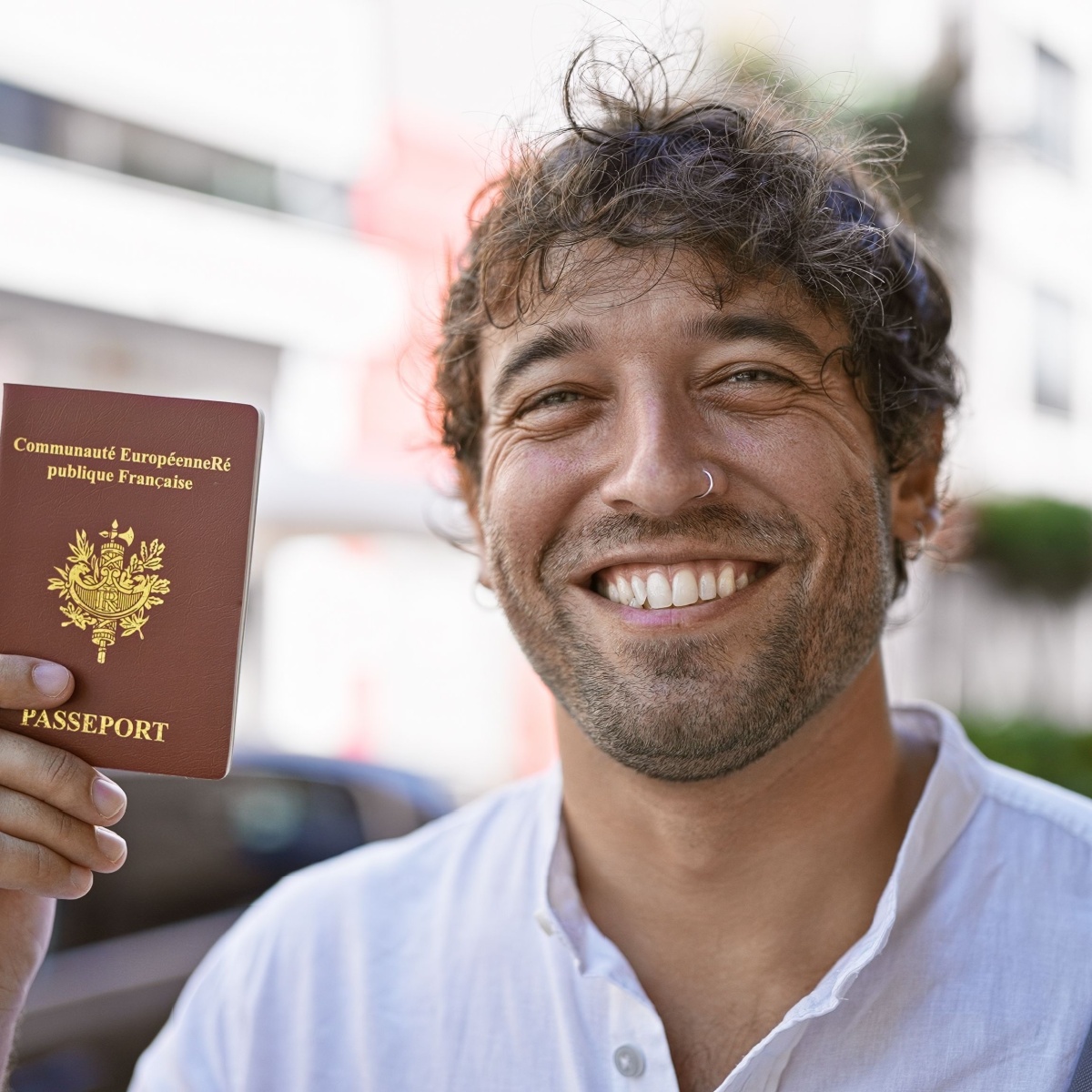 Persona sosteniendo un pasaporte francés, imagen ilustrativa sobre impatriados y Ley Beckham en España, por exención por reinversión en vivienda habitual por traslado laboral