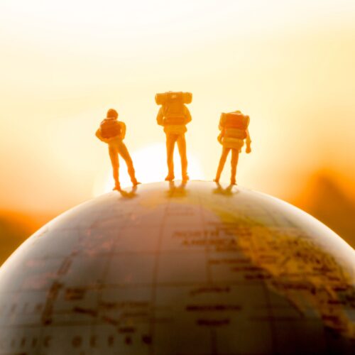 Viajeros sobre un globo al amanecer, imagen de movilidad internacional e impatriados para Ley Beckham y donaciones del extranjero.