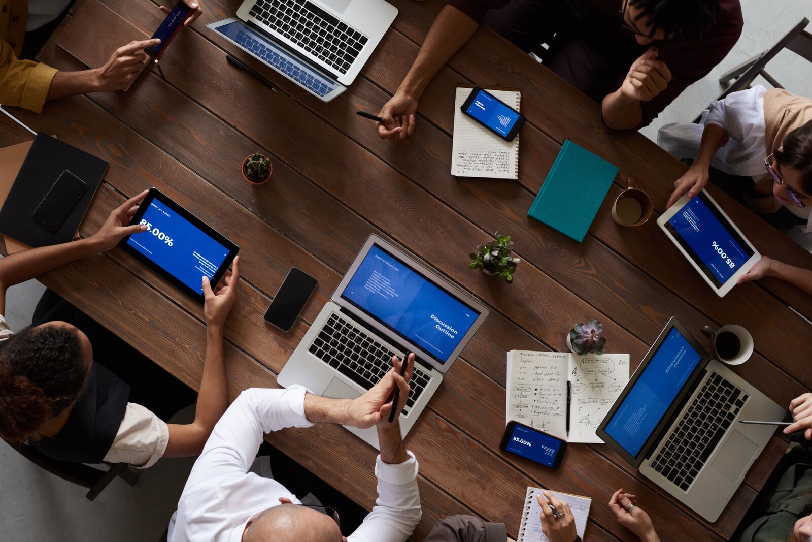 Equipo reunido con ordenadores y tabletas para analizar un proyecto empresarial