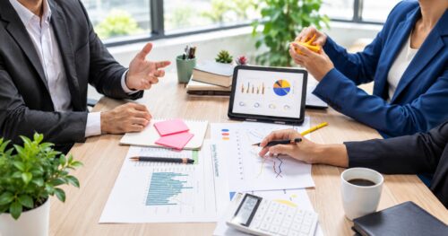 Professionals reviewing charts and financial forecasts for an ENISA business plan