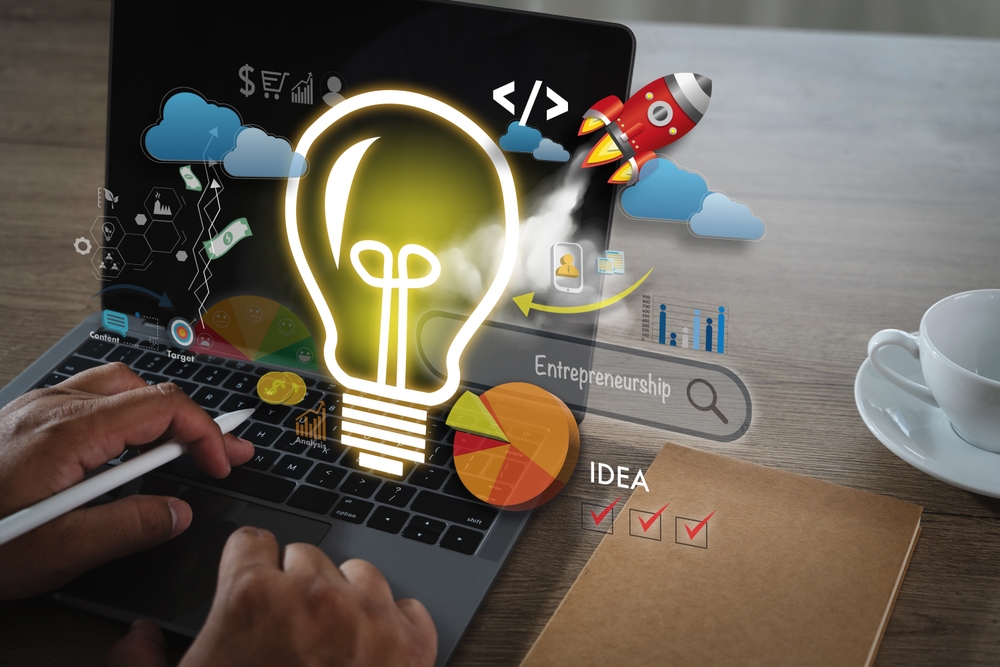 Ordenador portátil con una bombilla, un cohete y símbolos de innovación y emprendimiento