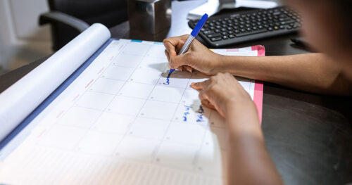 Persona anotando fechas en un calendario para planificar los plazos de ENISA y UGE