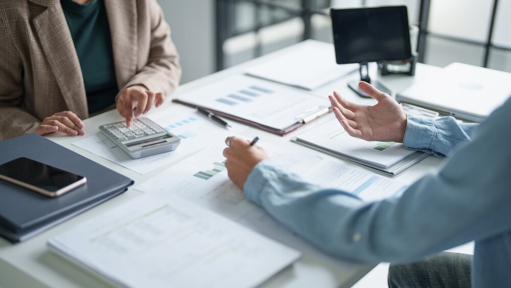 Advisers reviewing financial documents and calculations during a meeting